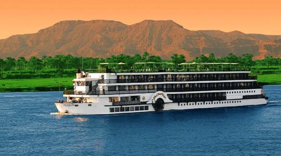 large boat on the water with a mountain in the background